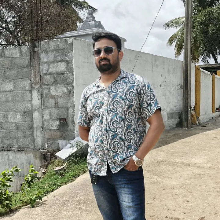 Pavan in a printed shirt and sunglasses on a sunny street